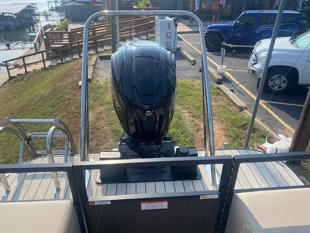 Slide: The Image of 2023 SunCatcher Fusion 324SS boat with powerful outboard motor, docked near a lakeside. - 10