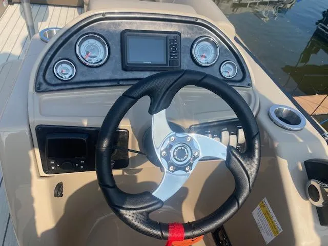 Slide: The Image of 2023 SunCatcher Fusion 324SS boat dashboard with steering wheel and gauges. - 16