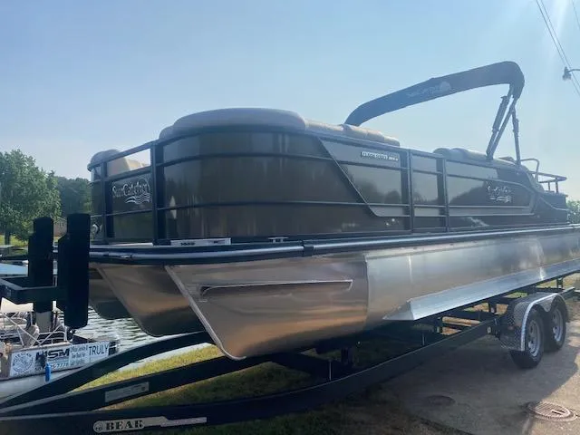 Slide: The Image of 2023 SunCatcher Fusion 324SS pontoon boat on trailer by a lake. - 3