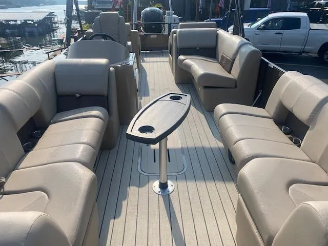 Slide: The Image of 2023 SunCatcher Fusion 324SS boat interior with beige seating and central table. - 6