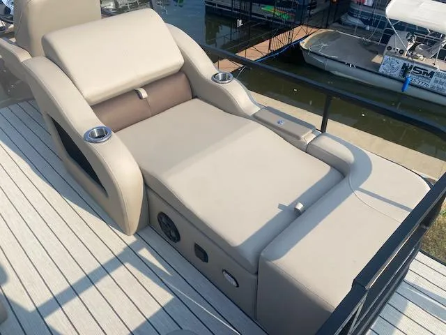 Slide: The Image of Luxurious SunCatcher Fusion 324SS 2023 boat seating with cup holders, docked by the water. - 7