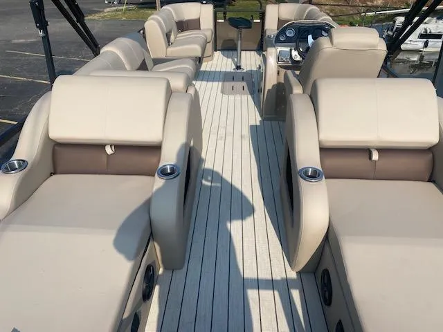 Slide: The Image of 2023 SunCatcher Fusion 324SS boat interior with beige seating and cup holders. - 9