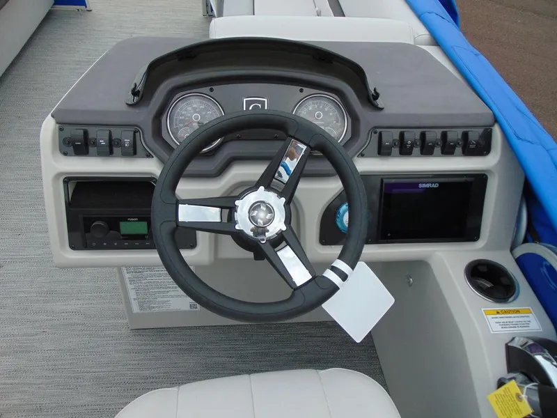 Slide: The Image of 2023 Godfrey Sweetwater 2286 FS boat dashboard with steering wheel and controls. - 1