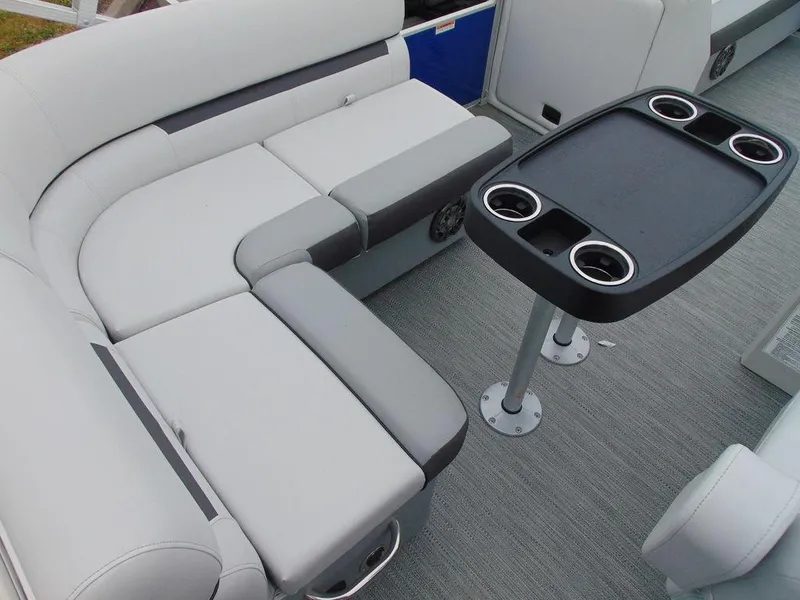 Slide: The Image of 2023 Godfrey Sweetwater 2286 FS boat interior with gray seating and table with cup holders. - 5