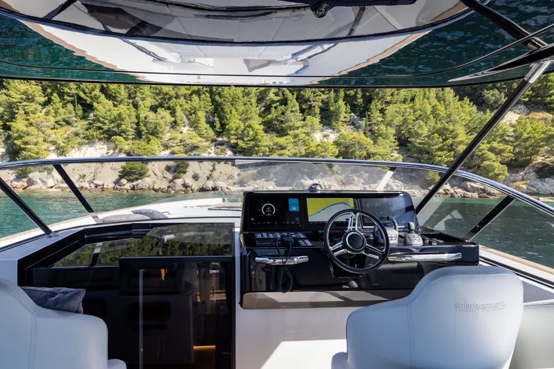 Slide: The Image of 2025 Solaris Power 60 Open yacht cockpit with modern controls and scenic coastal view. - 19