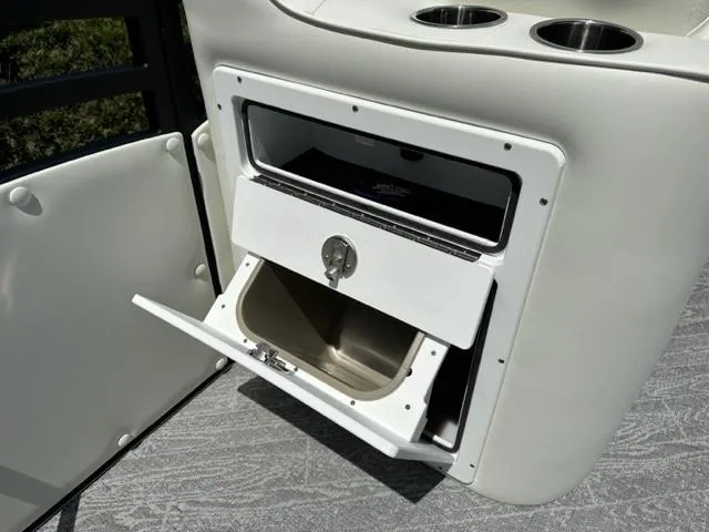 Slide: The Image of 2023 JC Neptoon 25 SB Sport boat storage compartment with cup holders. - 14