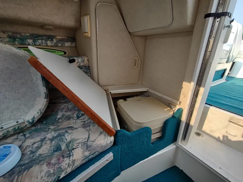 Slide: The Image of 1997 Sea Ray 240 SIGNATURE cabin interior with seating and compact toilet. - 18