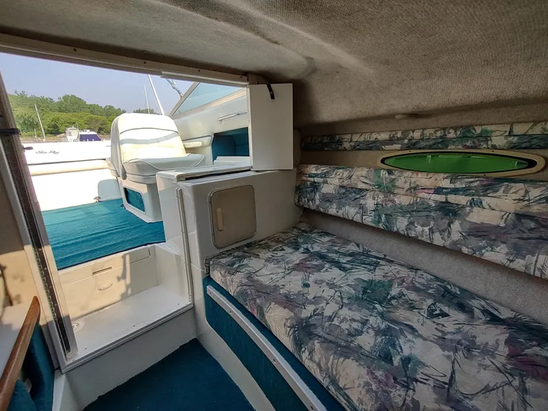 Slide: The Image of Interior of 1997 Sea Ray 240 SIGNATURE boat with patterned seating and open cabin view. - 21