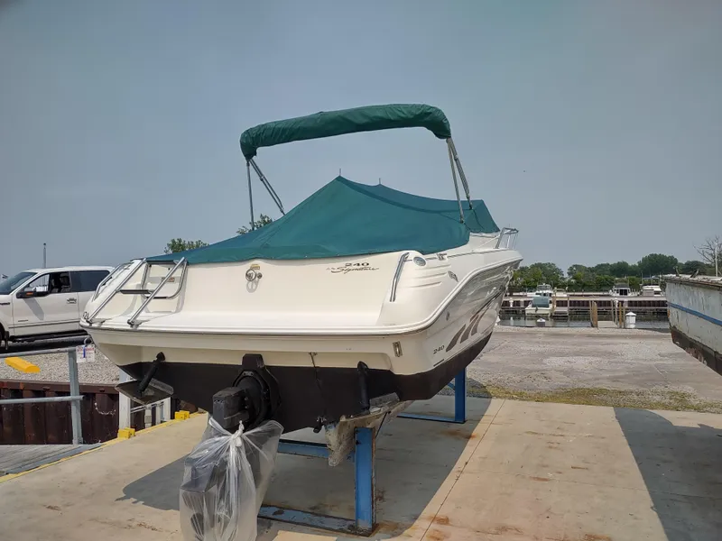 Slide: The Image of 1997 Sea Ray 240 SIGNATURE boat on a stand with green canopy. - 3
