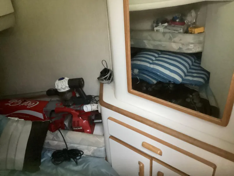 Slide: The Image of Interior cabin of a 1994 Sea Ray 370 Sedan Bridge with storage and cleaning equipment. - 12