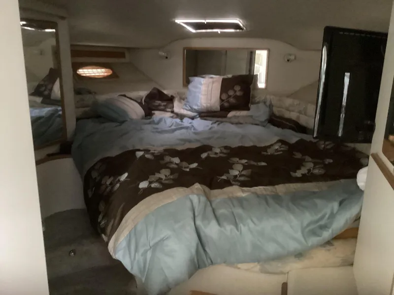 Slide: The Image of 1994 Sea Ray 370 Sedan Bridge cabin with a cozy bed and floral bedding. - 13