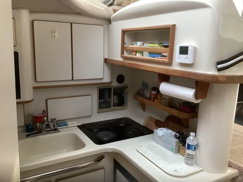 Slide: The Image of 1994 Sea Ray 370 Sedan Bridge kitchen with sink, stove, and storage cabinets. - 17