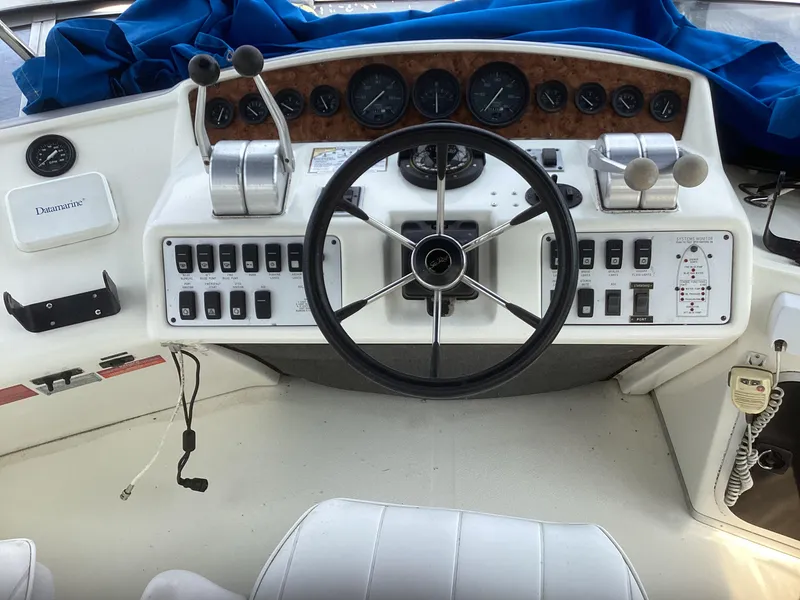 Slide: The Image of 1994 Sea Ray 370 Sedan Bridge helm with steering wheel, controls, and instrument panel. - 28