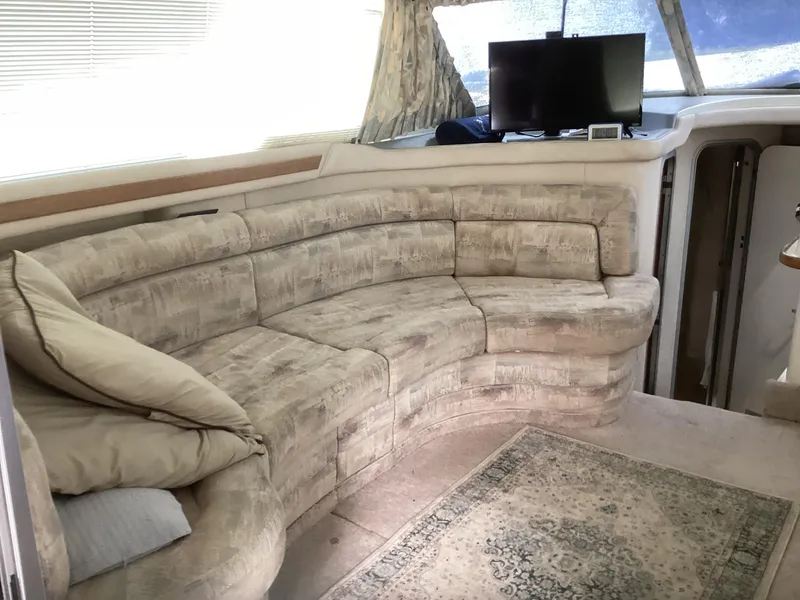 Slide: The Image of Interior of 1994 Sea Ray 370 Sedan Bridge with curved sofa and TV. - 4