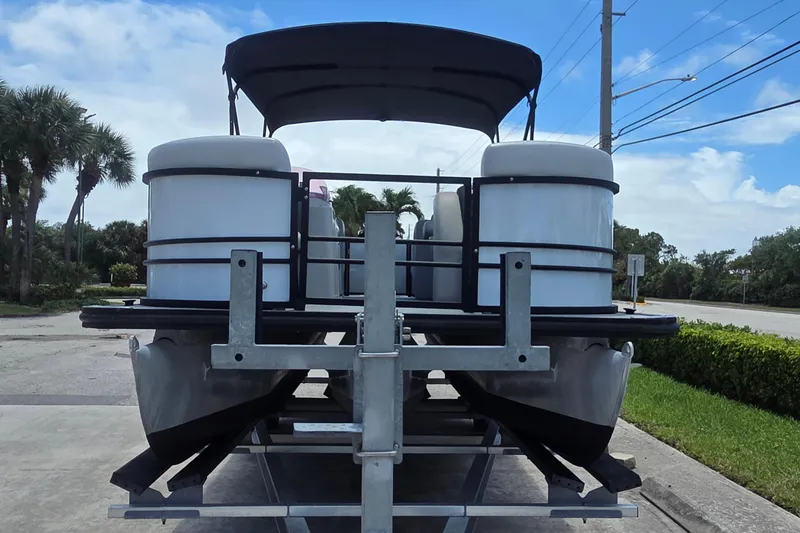 Slide: The Image of 2022 Sylvan Mirage X X3 pontoon boat on trailer, parked outdoors under blue sky. - 10