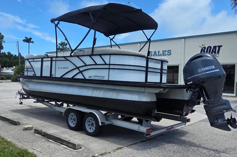 Slide: The Image of 2022 Sylvan Mirage X X3 pontoon boat with Yamaha motor on trailer at dealership. - 12