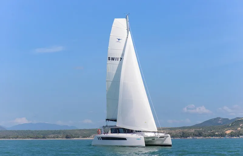 Slide: The Image of 2025 Seawind 1170 catamaran sailing on calm waters under a clear blue sky. - 13