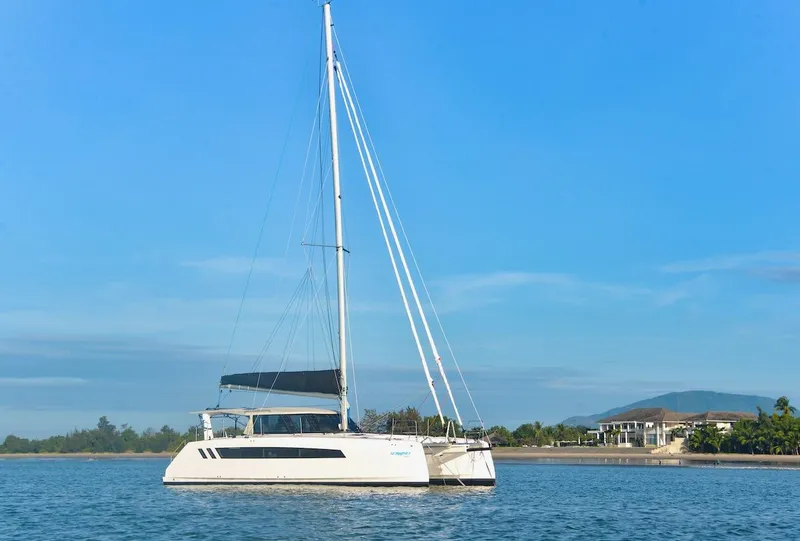 Slide: The Image of 2025 Seawind 1170 catamaran sailing on calm waters near a coastal landscape. - 15