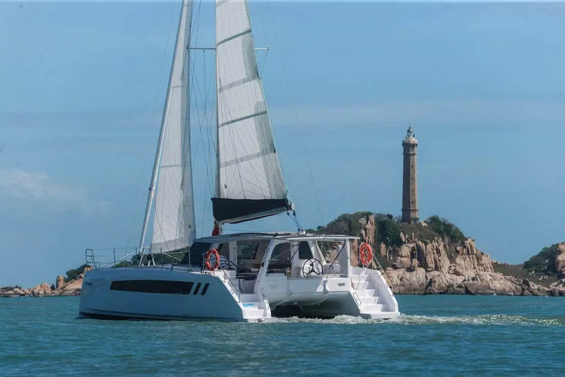 Slide: The Image of 2025 Seawind 1170 catamaran sailing near a lighthouse on a clear day. - 19