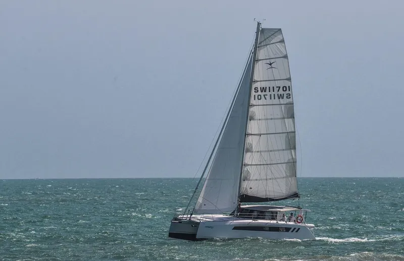 Slide: The Image of 2025 Seawind 1170 catamaran sailing on open sea with full sails. - 24