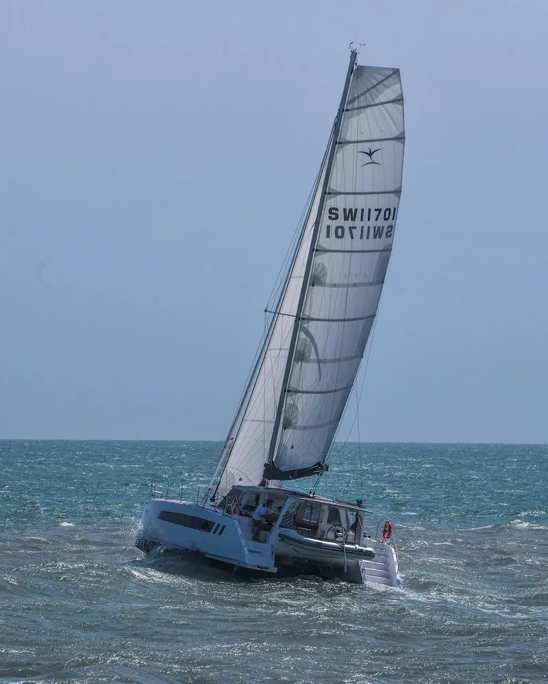 Slide: The Image of 2025 Seawind 1170 catamaran sailing on open sea with full sails. - 25