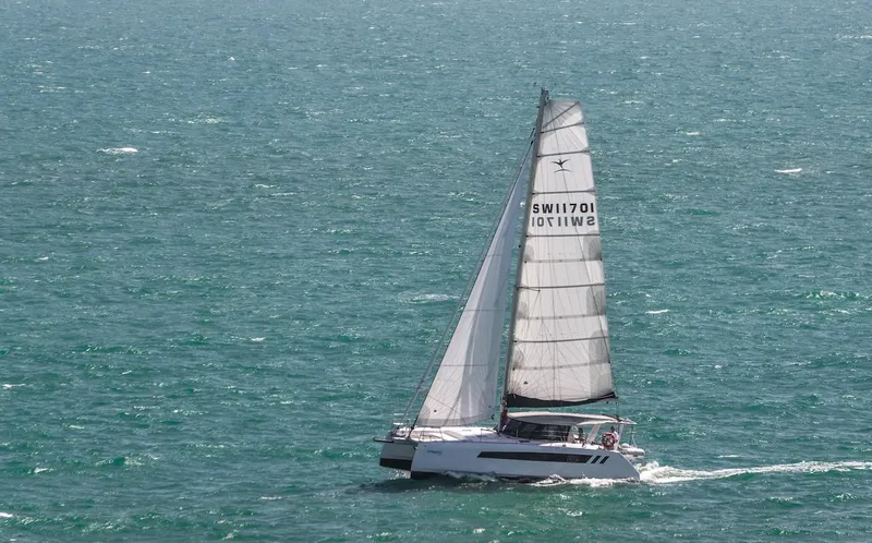 Slide: The Image of 2025 Seawind 1170 catamaran sailing on open sea with full sails. - 31