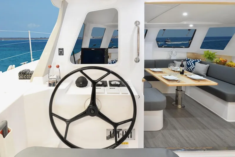 Slide: The Image of 2025 Seawind 1170 yacht interior with helm, dining area, and ocean view. - 43