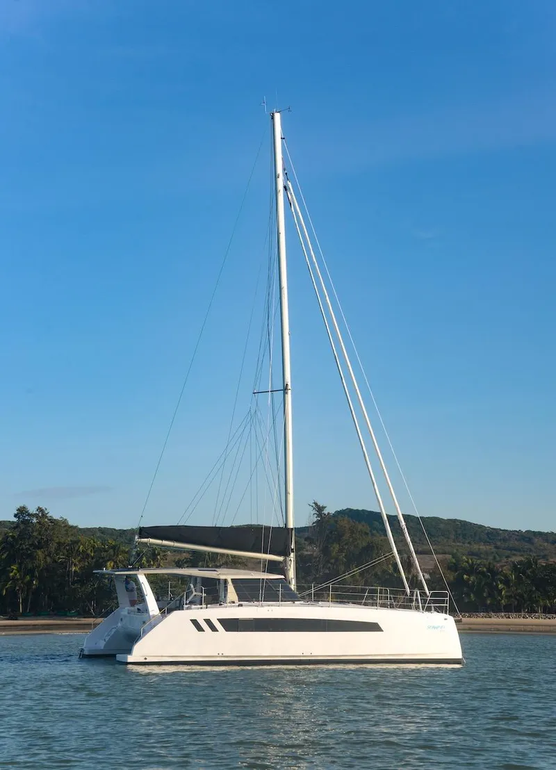Slide: The Image of 2025 Seawind 1170 catamaran sailing on calm waters under a clear blue sky. - 9