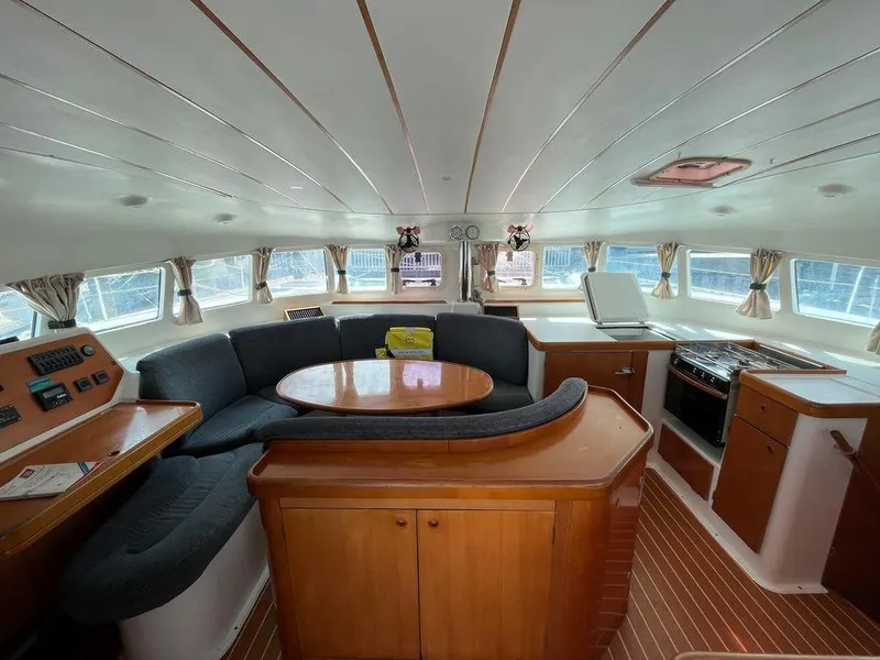 Slide: The Image of Interior of 2005 Lagoon 410 catamaran with spacious seating and dining area. - 10