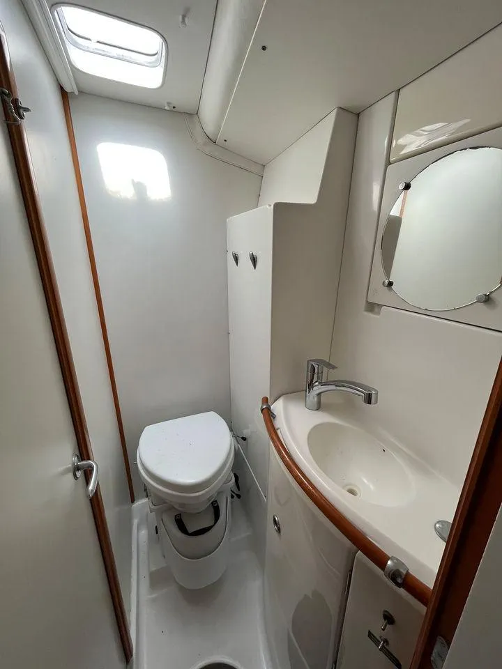 Slide: The Image of 2005 Lagoon 410 boat bathroom with toilet, sink, and mirror. - 18