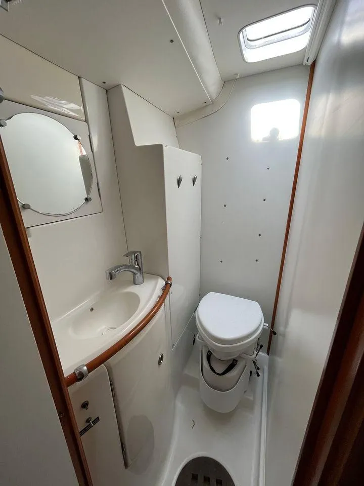Slide: The Image of Compact bathroom in 2005 Lagoon 410 catamaran with sink, toilet, and mirror. - 19