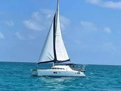 Slide: The Image of 2005 Lagoon 410 catamaran sailing on clear blue ocean under sunny skies. - 2