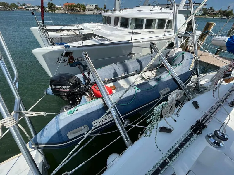 Slide: The Image of Lagoon 410 catamaran (2005) docked with an inflatable dinghy and Mercury outboard motor. - 23