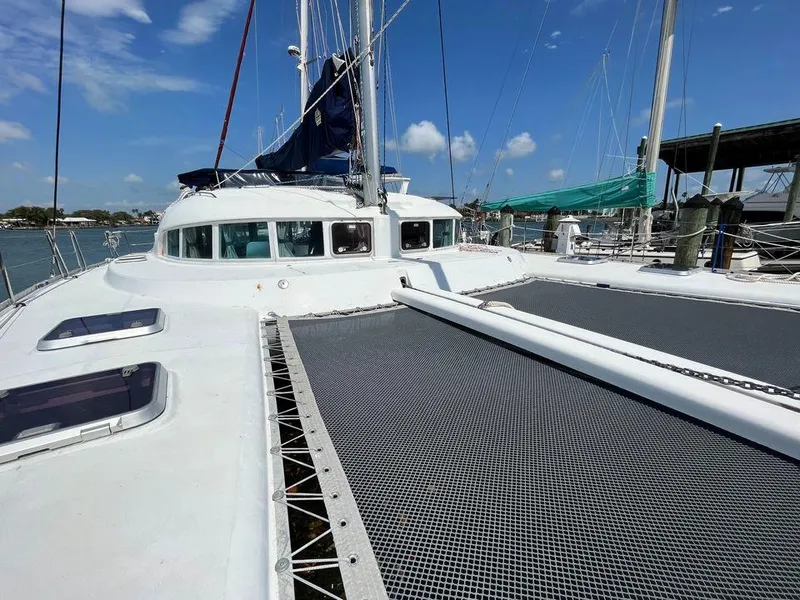 Slide: The Image of 2005 Lagoon 410 catamaran deck with netting and clear sky. - 5