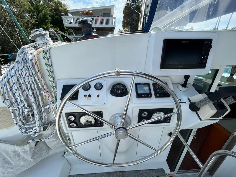 Slide: The Image of Lagoon 410 2005 sailboat helm with steering wheel, navigation instruments, and ropes. - 6
