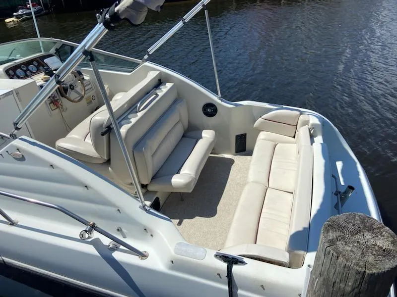 Slide: The Image of 1997 Crownline 250 CR boat with spacious seating, docked by the water. - 2