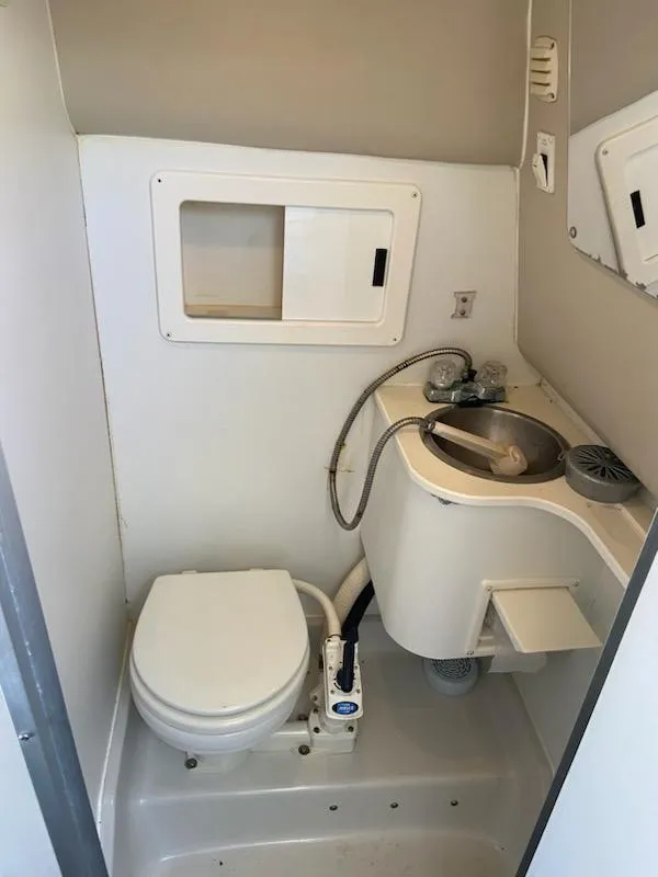 Slide: The Image of 1997 Crownline 250 CR boat bathroom with toilet, sink, and storage compartments. - 6