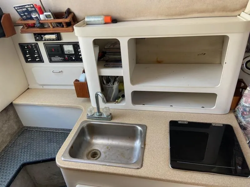 Slide: The Image of 1997 Crownline 250 CR boat interior with sink, stove, and storage compartments. - 7