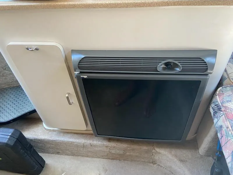 Slide: The Image of 1997 Crownline 250 CR cabin interior with compact fridge and storage cabinet. - 9