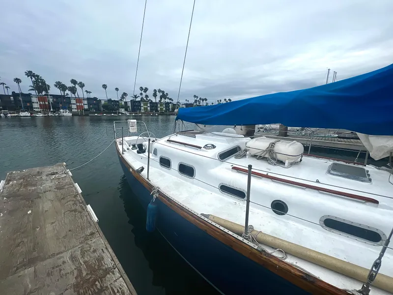 Slide: The Image of 1977 Van De Stadt Rebel 42 sailboat docked, featuring a blue hull and white deck. - 16