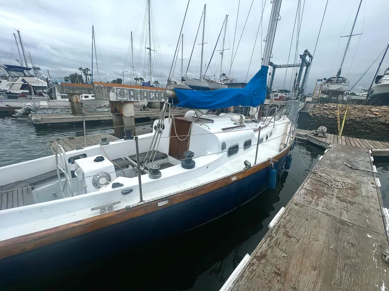 Slide: The Image of 1977 Van De Stadt Rebel 42 sailboat docked at a marina, featuring a blue hull and white deck. - 18