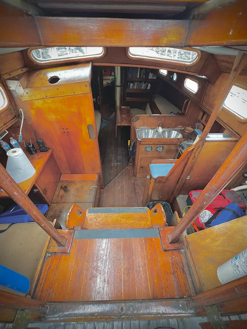 Slide: The Image of 1977 Van De Stadt Rebel 42 yacht interior with wooden finish, compact kitchen, and cozy living space. - 29