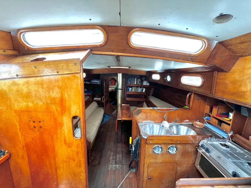 Slide: The Image of Interior of 1977 Van De Stadt Rebel 42 sailboat with wooden cabinetry and compact kitchen. - 30