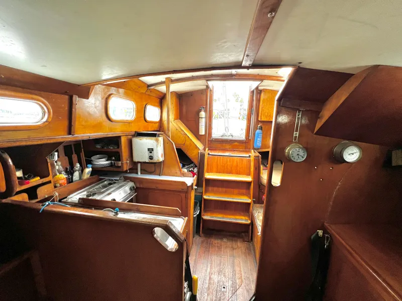 Slide: The Image of 1977 Van De Stadt Rebel 42 yacht interior with wooden finish and compact kitchen area. - 39