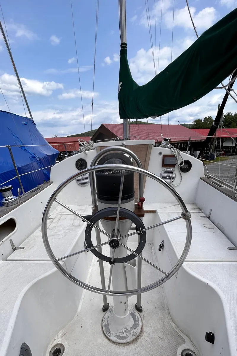 Slide: The Image of 1979 Sabre 28-2 sailboat cockpit with steering wheel and green sail cover. - 17