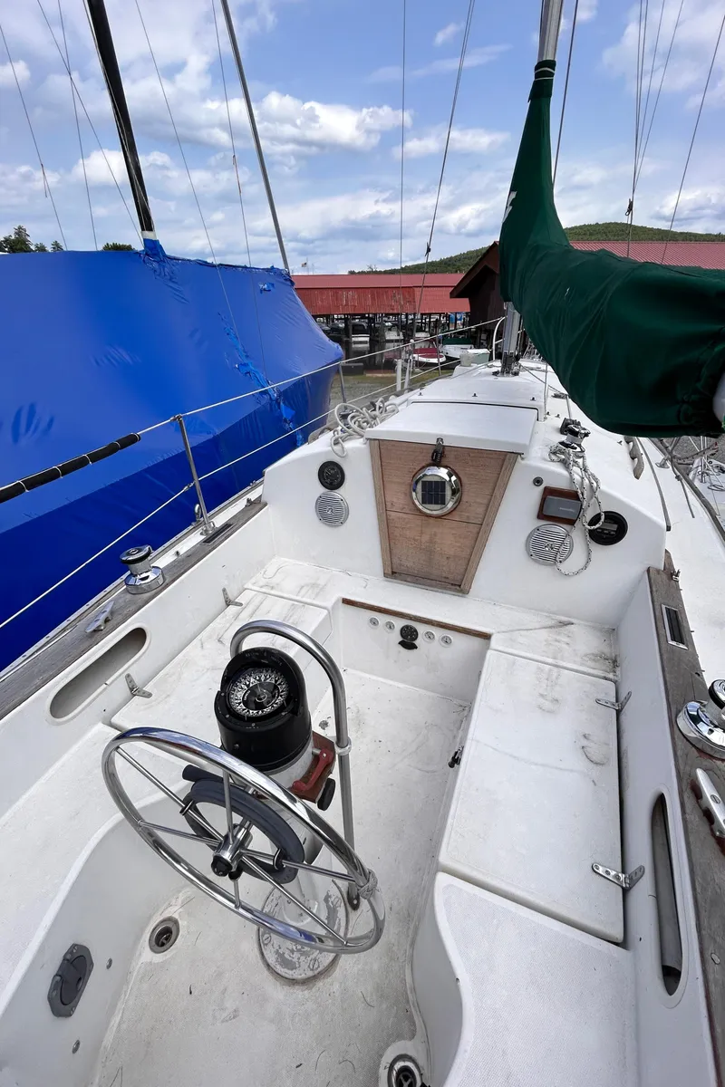 Slide: The Image of 1979 Sabre 28-2 sailboat cockpit with steering wheel and covered sails. - 18