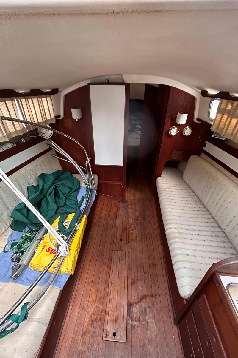 Slide: The Image of 1979 Sabre 28-2 sailboat interior with wooden flooring and cushioned seating. - 24