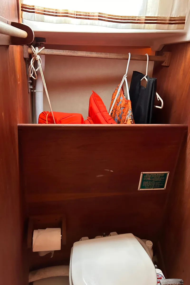 Slide: The Image of 1979 Sabre 28-2 boat bathroom with toilet, life jackets, and storage. - 29
