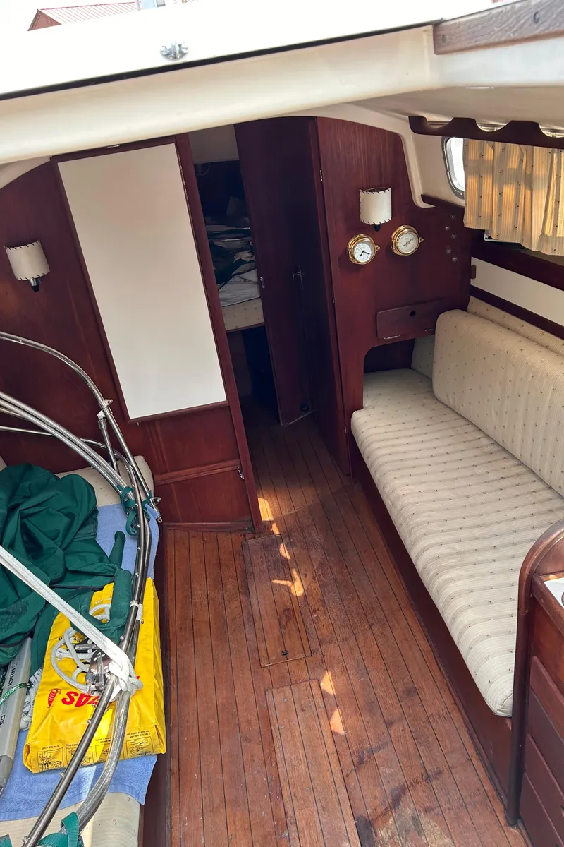 Slide: The Image of Interior of a 1979 Sabre 28-2 sailboat with wooden flooring and cushioned seating. - 33