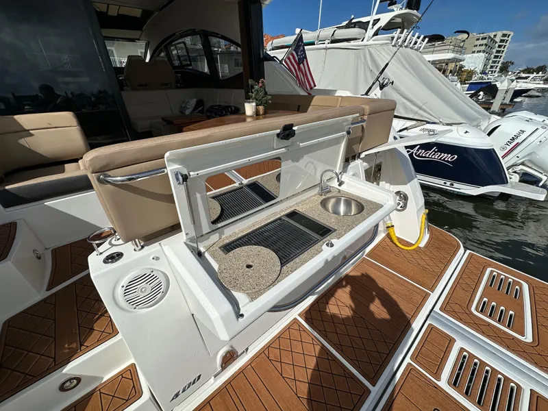 Slide: The Image of Die Sea Ray Sundancer 400 von 2017 zeigt eine Außenküche mit Spüle und Grill auf dem Deck. - 22